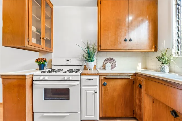 a kitchen with stainless steel appliances white cabinets and a stove top oven