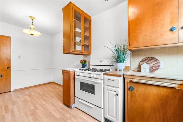 a kitchen with stainless steel appliances granite countertop a stove a sink and a refrigerator with wooden floors