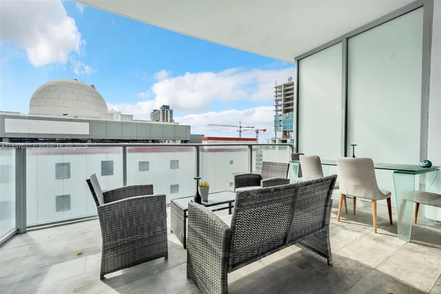 a living room with furniture a fireplace and a floor to ceiling window
