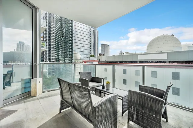 a dining room with furniture and a floor to ceiling window