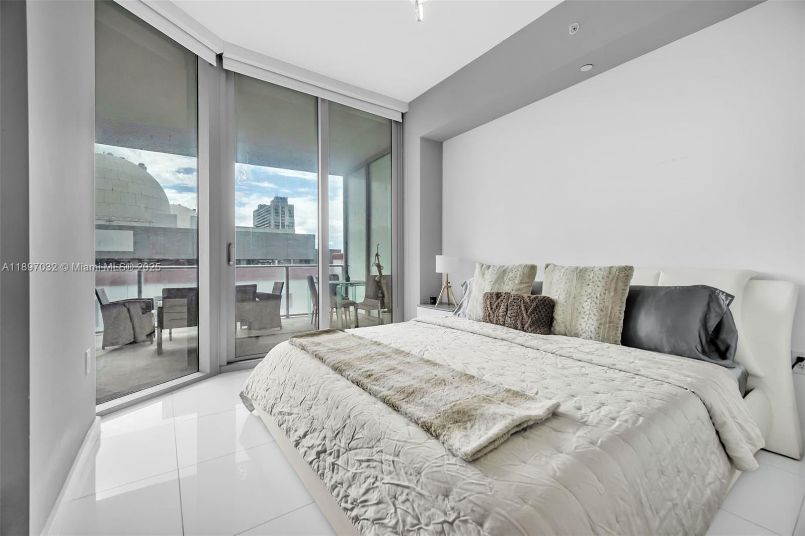 851 Northeast 1st Avenue, Unit 806 Miami, FL 33132 - Photo 19 of 51 a bedroom with a large bed and a large window