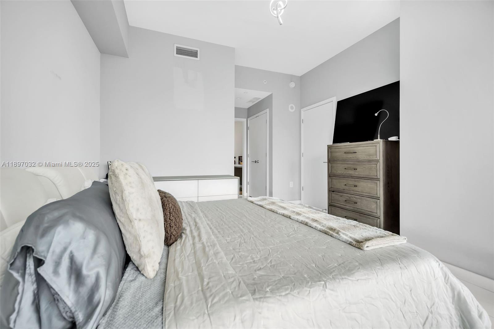 851 Northeast 1st Avenue, Unit 806 Miami, FL 33132 - Photo 20 of 51 a bedroom with a bed and dresser