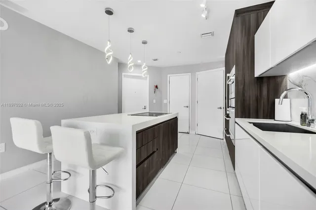 a large white kitchen with a sink and dishwasher a stove with wooden floor