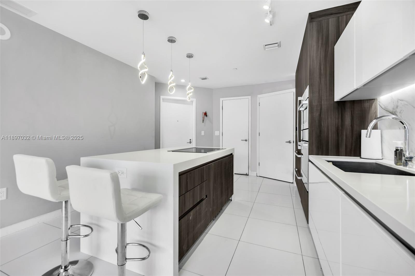 851 Northeast 1st Avenue, Unit 806 Miami, FL 33132 - Photo 3 of 51 a large white kitchen with a sink and dishwasher a stove with wooden floor