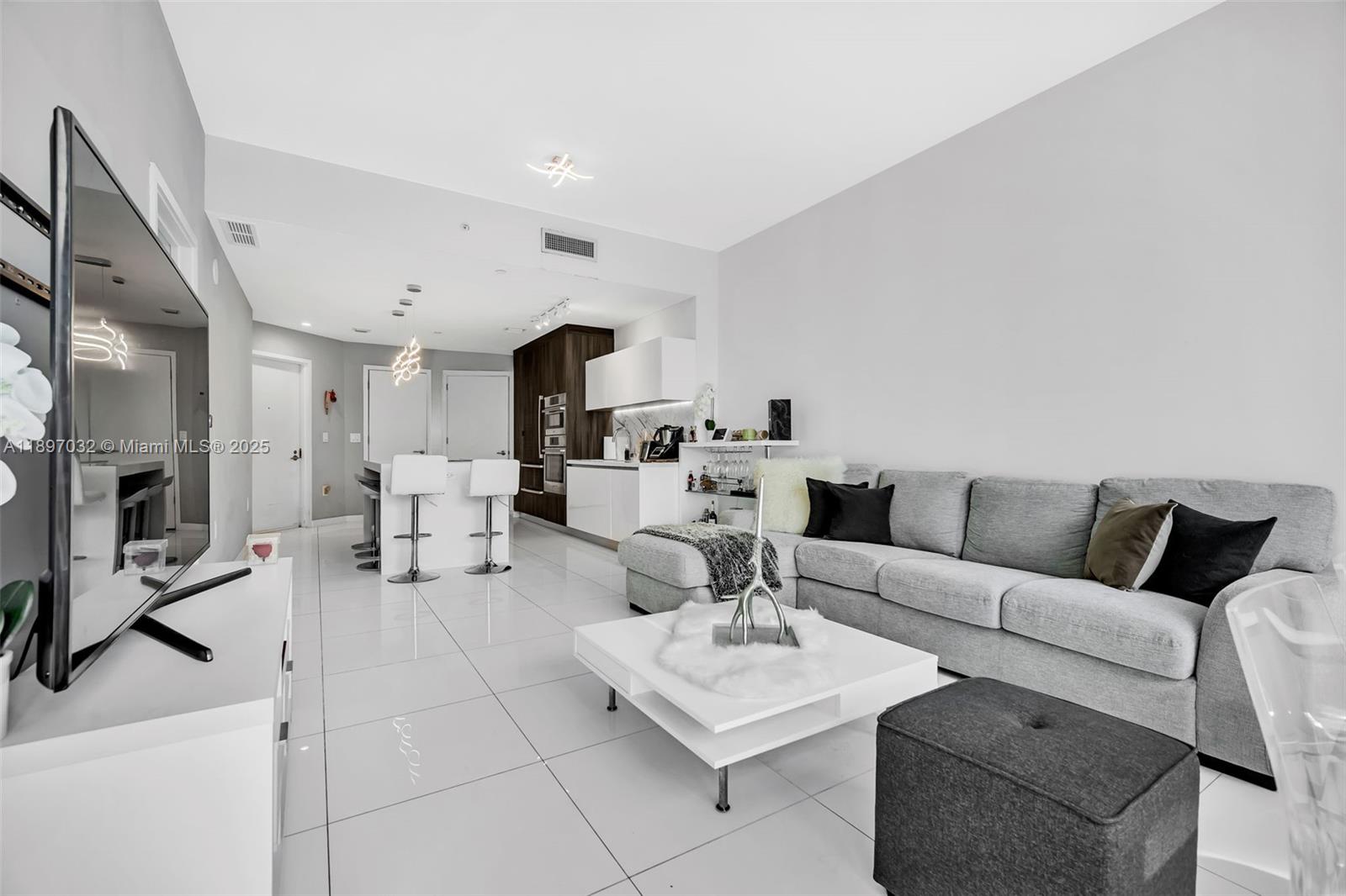 851 Northeast 1st Avenue, Unit 806 Miami, FL 33132 - Photo 4 of 51 a living room with furniture a fireplace and a flat screen tv