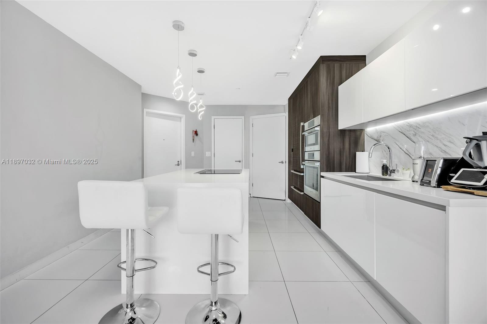 851 Northeast 1st Avenue, Unit 806 Miami, FL 33132 - Photo 5 of 51 a kitchen with kitchen island stainless steel appliances a sink and cabinets