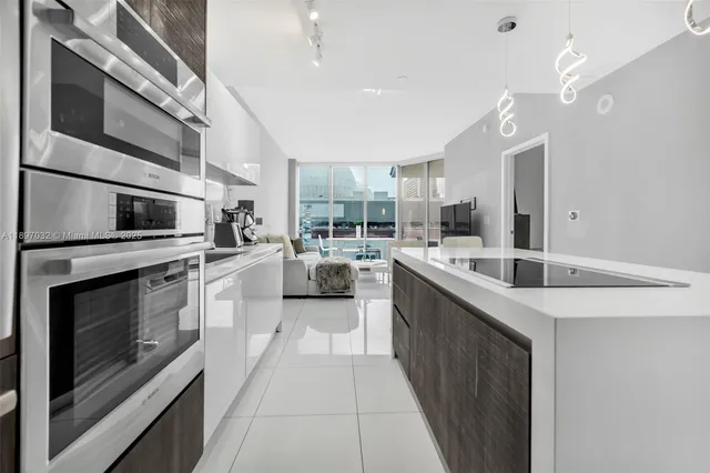 a kitchen with stainless steel appliances kitchen island granite countertop a sink and stove top oven