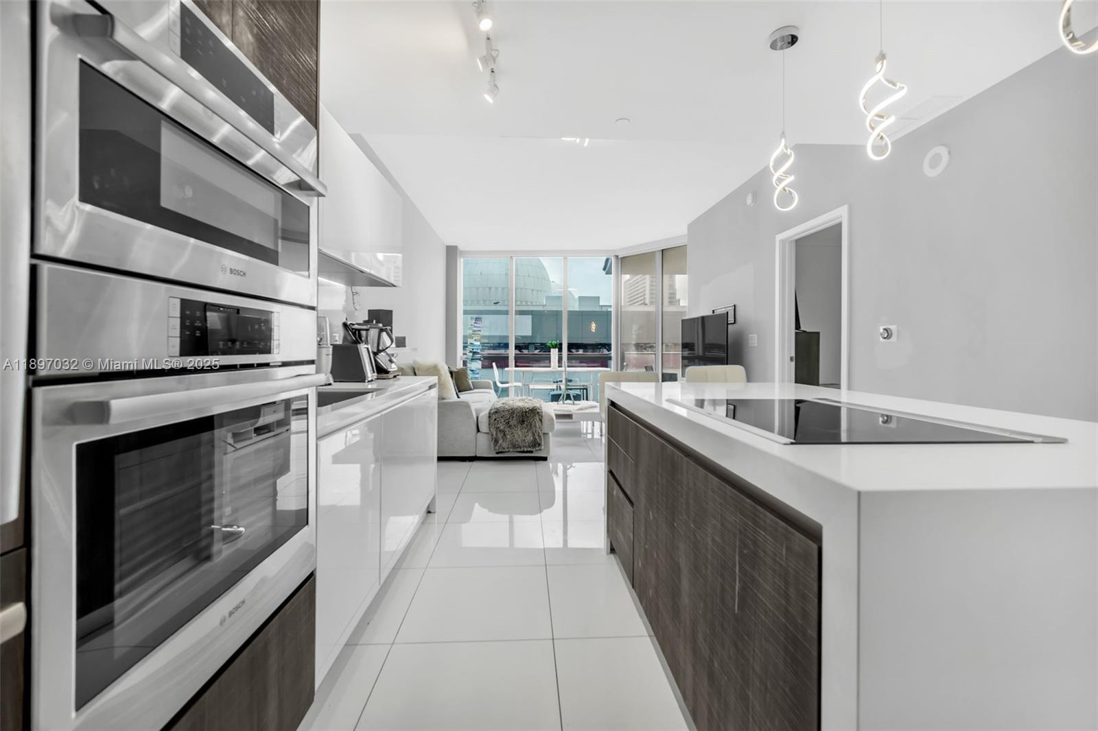 851 Northeast 1st Avenue, Unit 806 Miami, FL 33132 - Photo 6 of 51 a kitchen with stainless steel appliances kitchen island granite countertop a sink and stove top oven