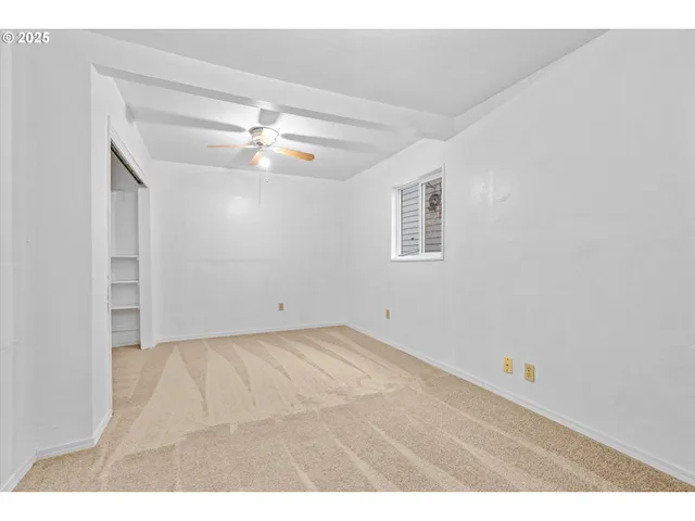 a view of an empty room with a ceiling fan