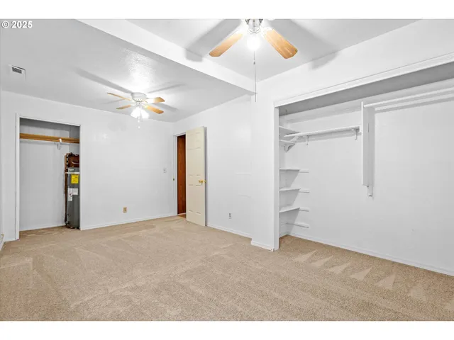 a view of an empty room with a ceiling fan