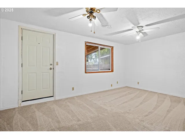 a view of an empty room with a ceiling fan