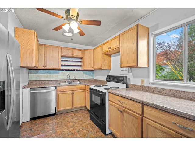 a kitchen with stainless steel appliances granite countertop a stove a sink and white cabinets
