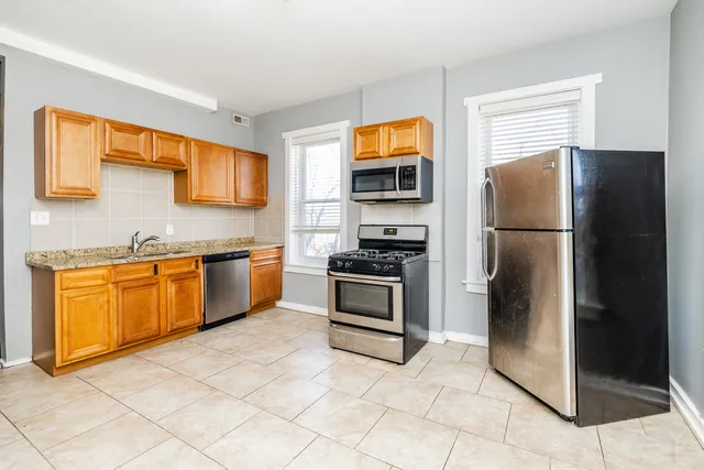 a kitchen with stainless steel appliances granite countertop a refrigerator stove and sink