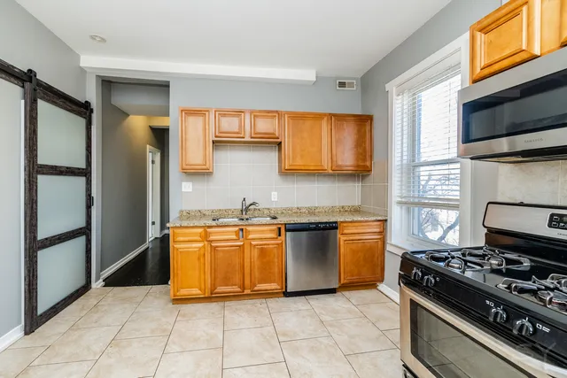 a kitchen with stainless steel appliances granite countertop a stove top oven a sink and dishwasher