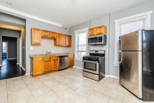 a kitchen with stainless steel appliances granite countertop a stove a refrigerator and a sink