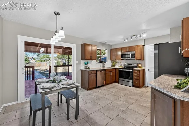 a kitchen with stainless steel appliances kitchen island granite countertop a sink refrigerator and cabinets