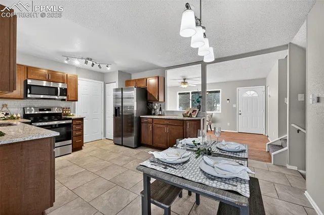 a kitchen with kitchen island a counter top space a sink stainless steel appliances and cabinets