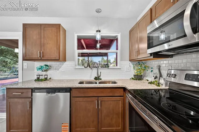 a kitchen with stainless steel appliances granite countertop a sink stove and microwave