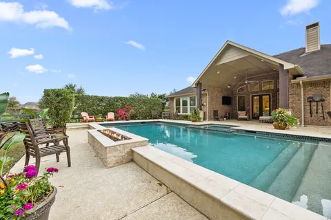 a view of swimming pool with outdoor seating and a patio