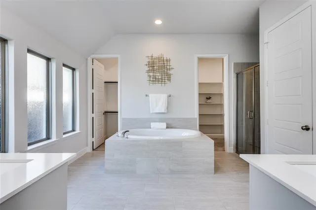 a spacious bedroom with a large bed and a chandelier