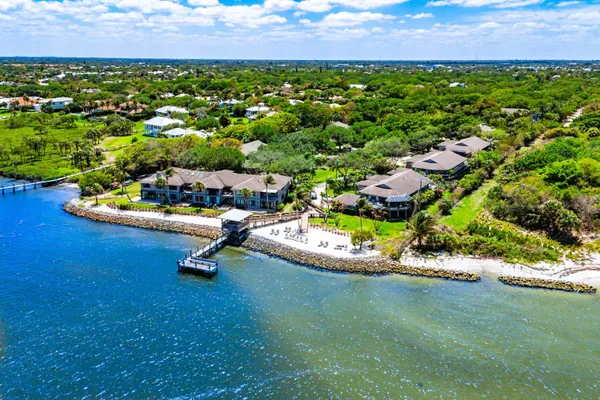 an aerial view of a house with a garden and lake view