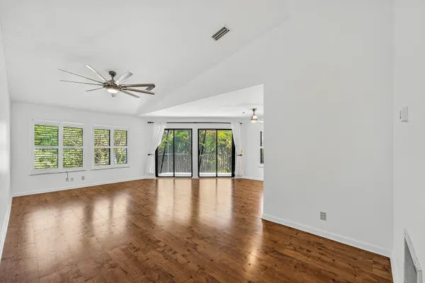 a view of an empty room with window and wooden floor