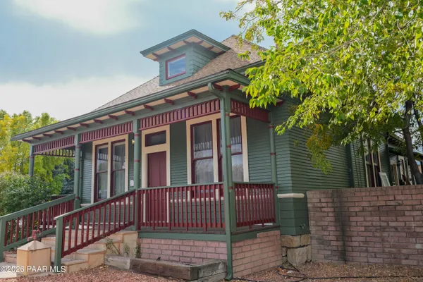a view of a house with a small yard and wooden fence