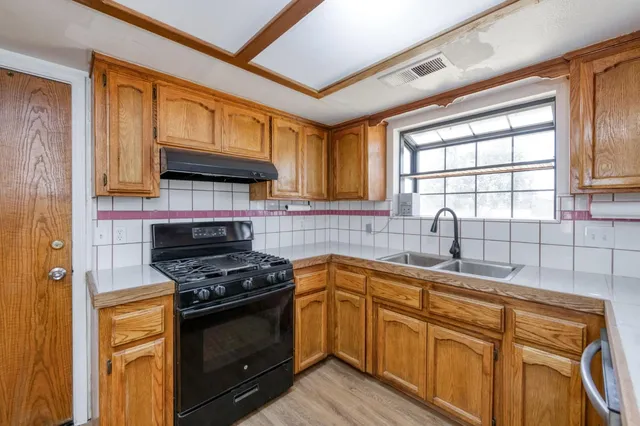 a kitchen with stainless steel appliances granite countertop a stove and a sink