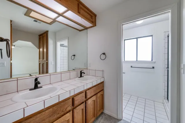 a bathroom with a granite countertop sink and a mirror