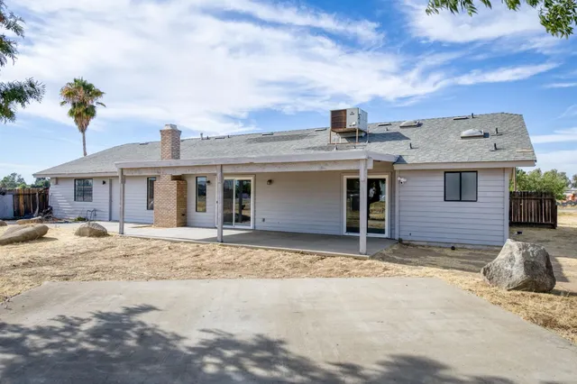 a tree in front of a white house