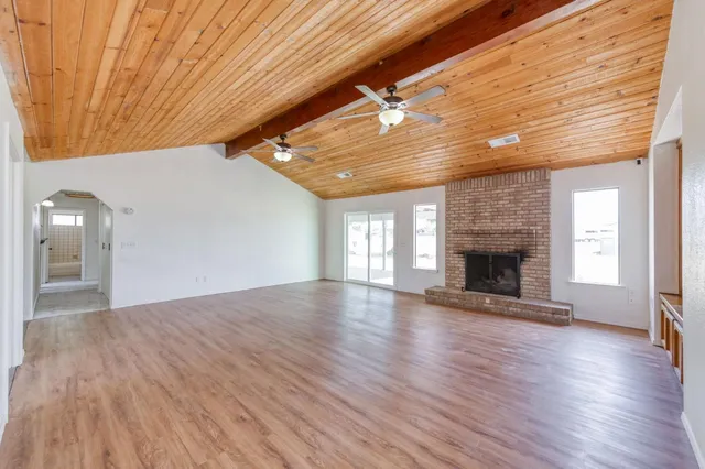 a view of empty room with wooden floor and fireplace
