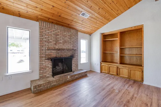 a living room with a fireplace and wooden floor