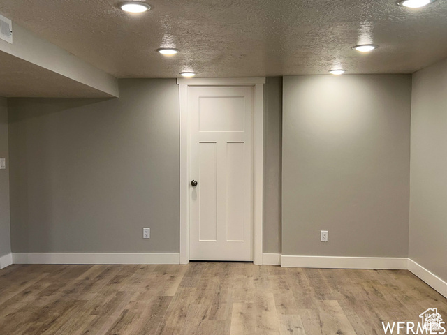 702 North 100 West Logan, UT 84321 - Photo 51 of 58 Finished below grade area with baseboards, light wood-style floors, and a textured ceiling