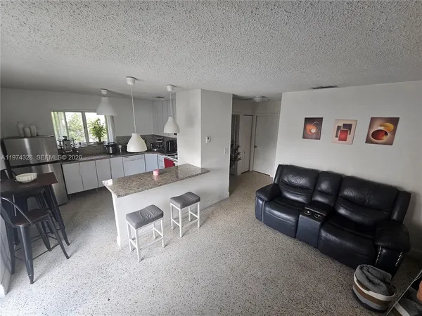 a living room with furniture and a dining table with kitchen view