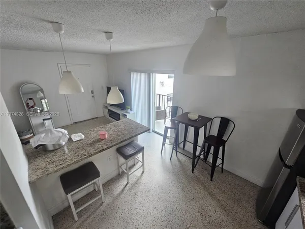 a large kitchen with stainless steel appliances granite countertop a stove a sink a dining table and chairs