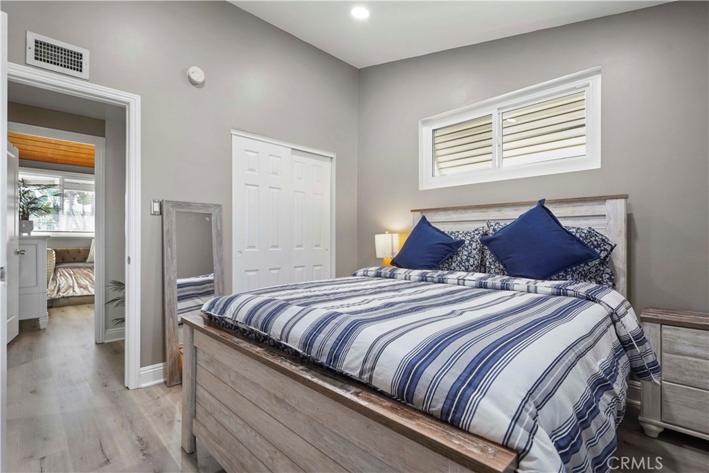 20448 Eccles Street Winnetka, CA 91306 - Photo 25 of 54 a bedroom with a bed and wooden floor