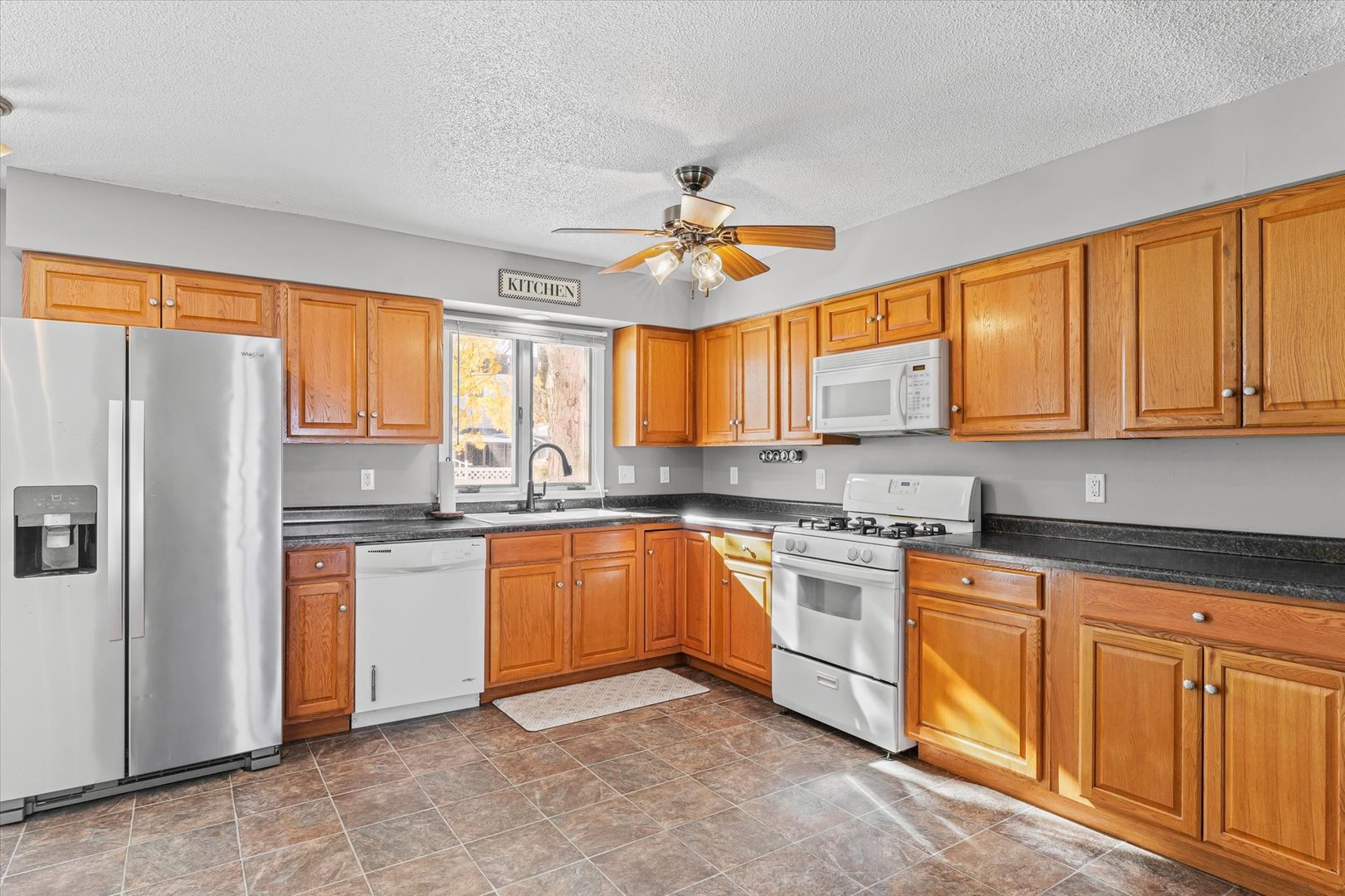 1058 North Drive Rantoul, IL 61866 - Photo 12 of 37 a kitchen with stainless steel appliances granite countertop a stove a sink dishwasher a refrigerator and cabinets with wooden floor
