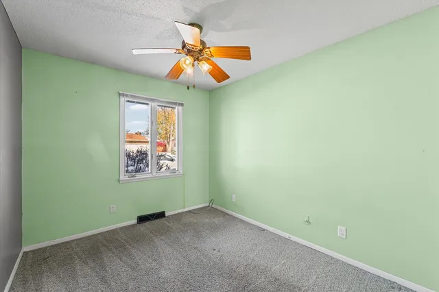 an empty room and chandelier fan