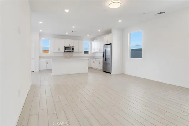 a view of kitchen with cabinets stainless steel appliances with wooden floor