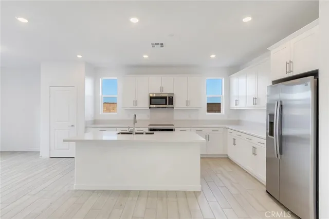 a kitchen with stainless steel appliances a refrigerator sink and cabinets