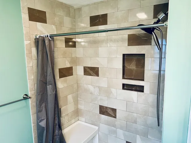 a bathroom with a shower and mirror