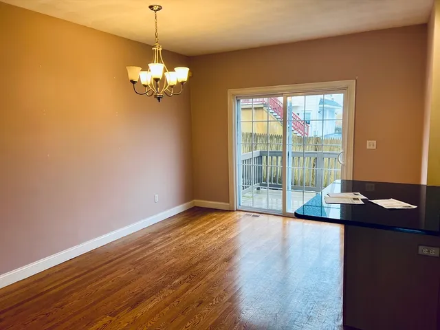 a view of a room with wooden floor and a ceiling fan