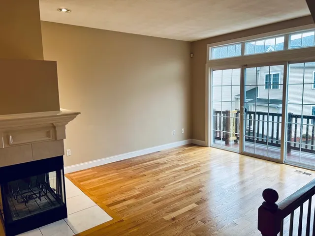 a view of a livingroom with wooden floor and a floor to ceiling window