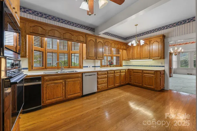 a kitchen with stainless steel appliances granite countertop a sink cabinets and a large window