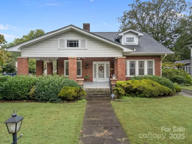 a front view of a house with a yard and potted plants