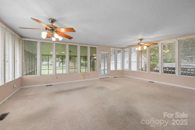 a view of an empty room with windows and city view