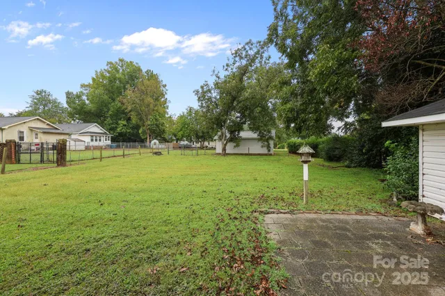 a view of a yard with a house and large trees