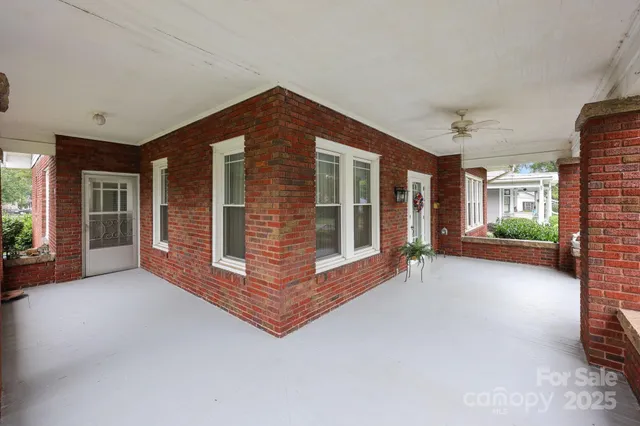 a view of an empty room with a fireplace and a window
