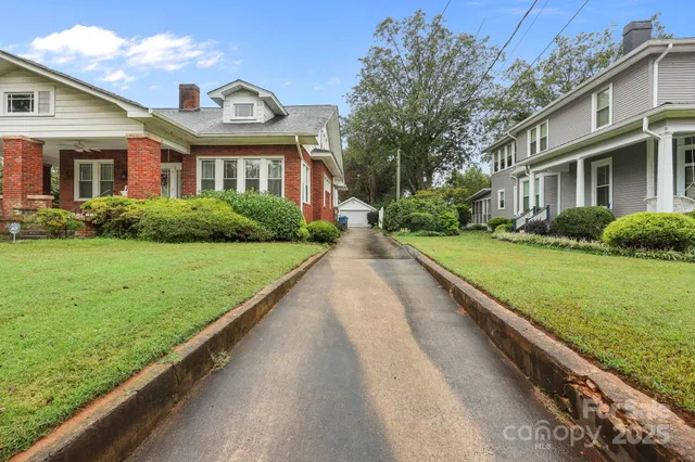 a view of a house with a yard and potted plants
