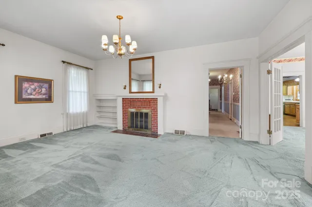 an empty room with windows and fireplace